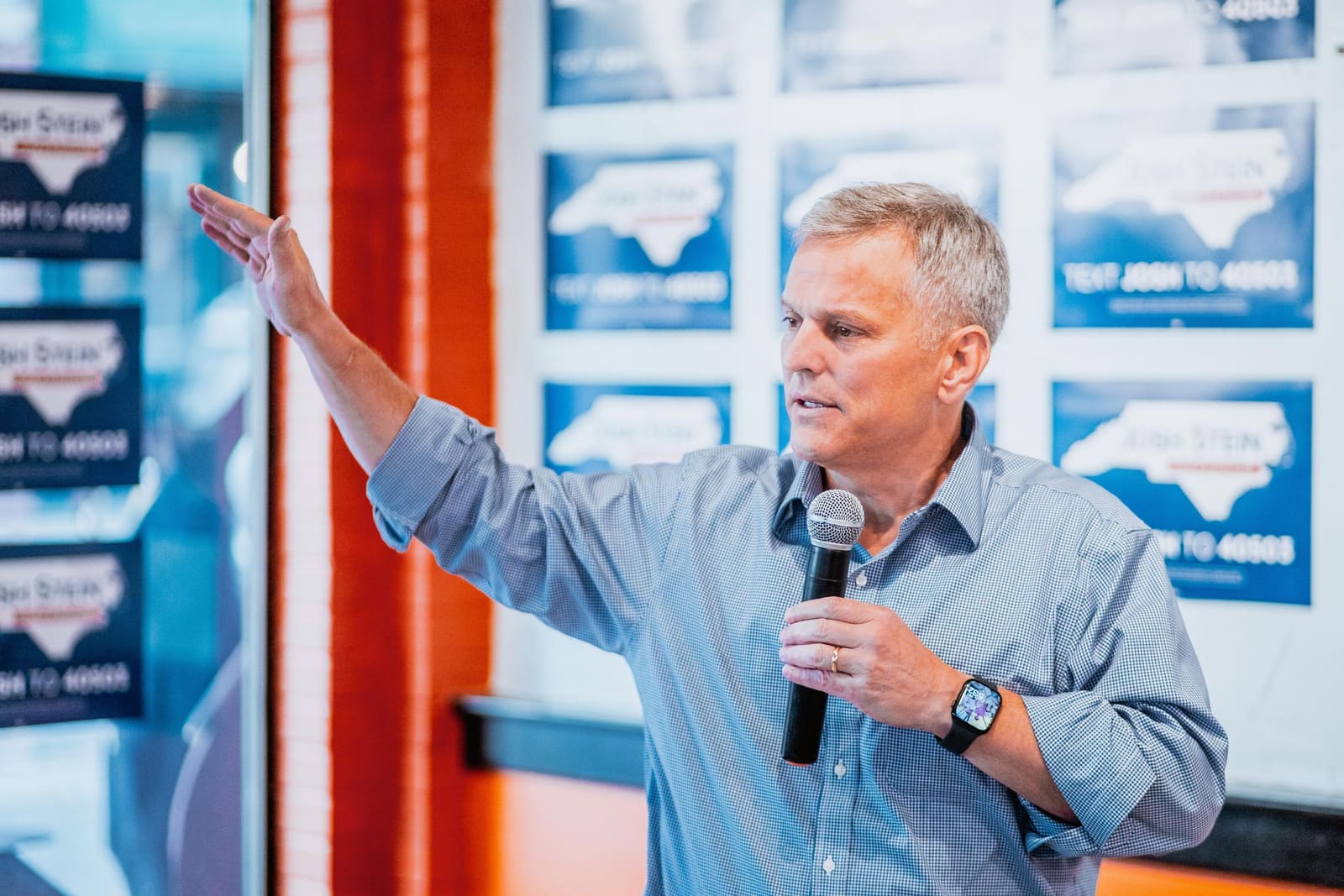 Josh Stein raises a hand while speaking in Greenville, NC, November 2024