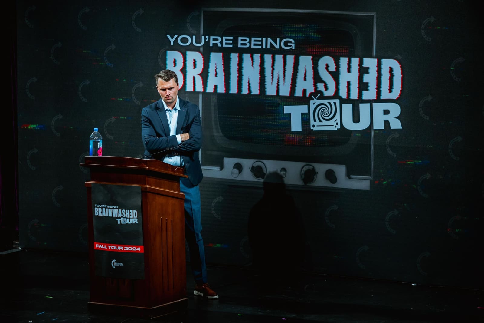 Charlie Kirk on stage beside the podium, Brainwashed Tour, fall 2024