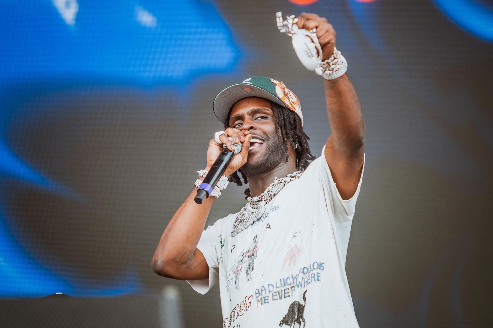 A performer in a graphic tee and cap sings at Dreamville Festival, Raleigh, 2025