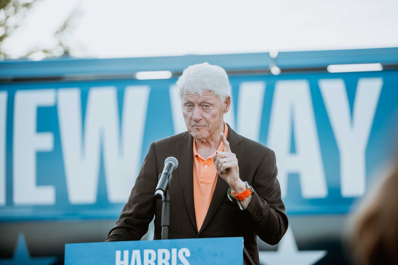 Bill Clinton at the podium in front of the A New Way Forward bus