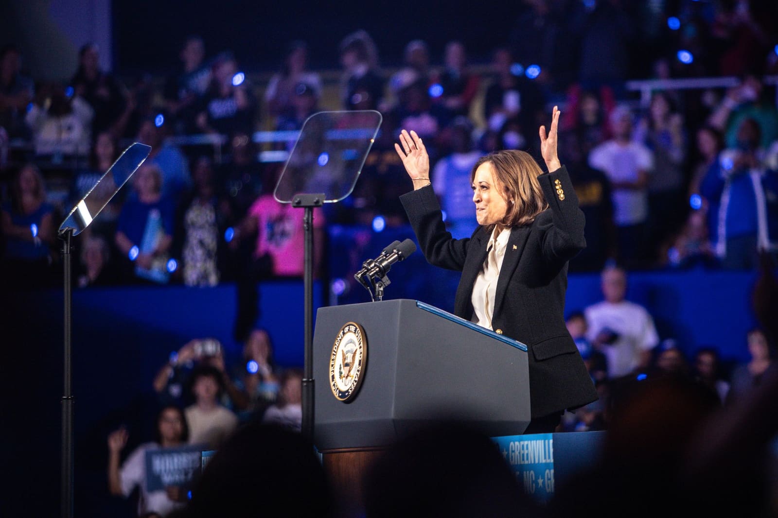 Kamala Harris raises both hands at the podium, Minges Coliseum, Greenville, NC