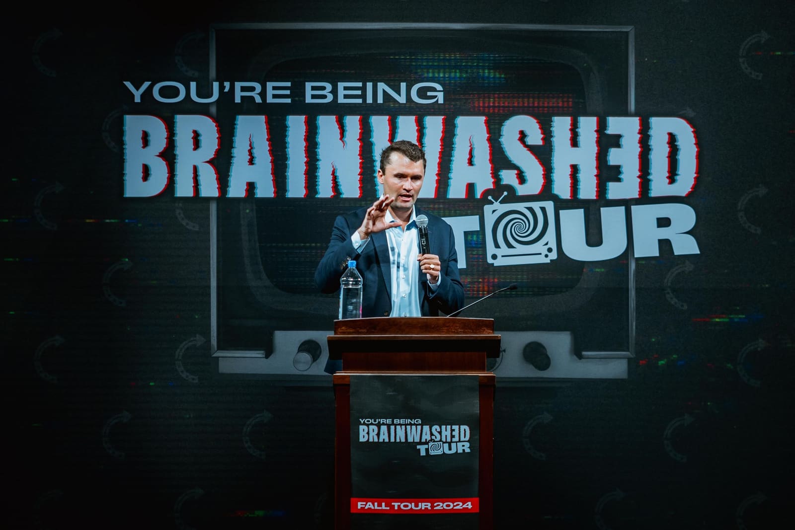 Charlie Kirk at the podium on the Brainwashed Tour stage, fall 2024