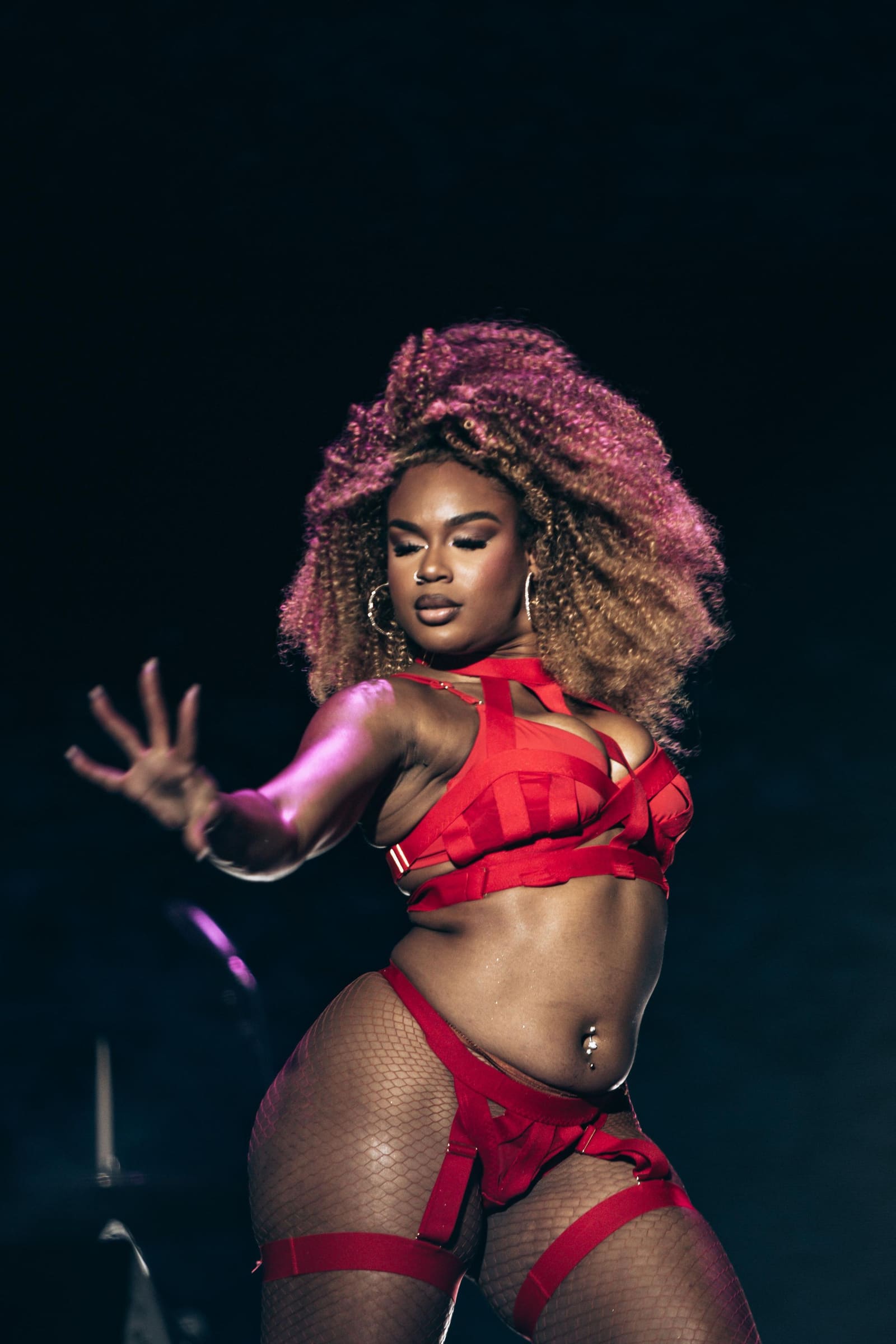A dancer in red performs under stage lights at Dreamville Festival, Raleigh, 2025