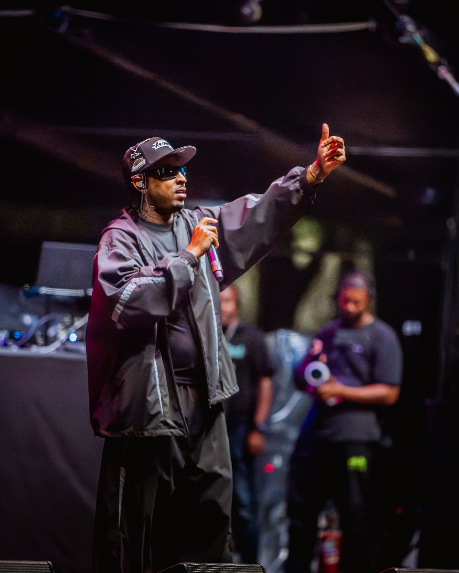A rapper in a dark jacket gestures on stage at Dreamville Festival, Raleigh, 2025