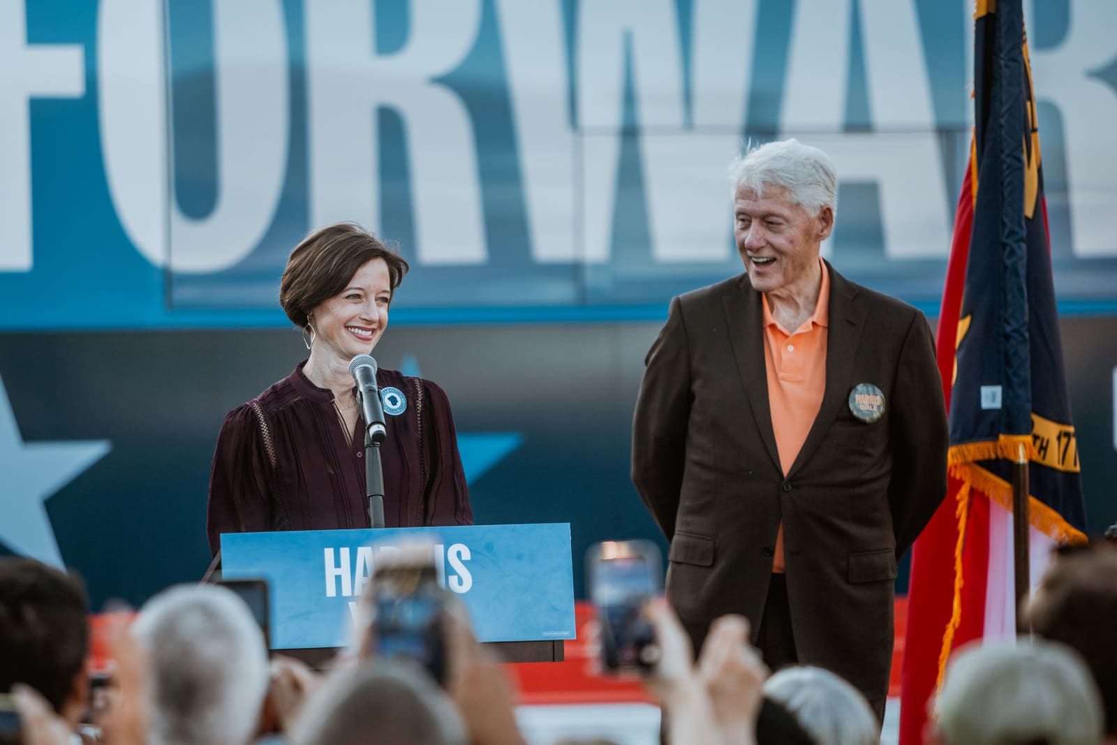 Bill Clinton smiles beside another speaker at the Forward stage
