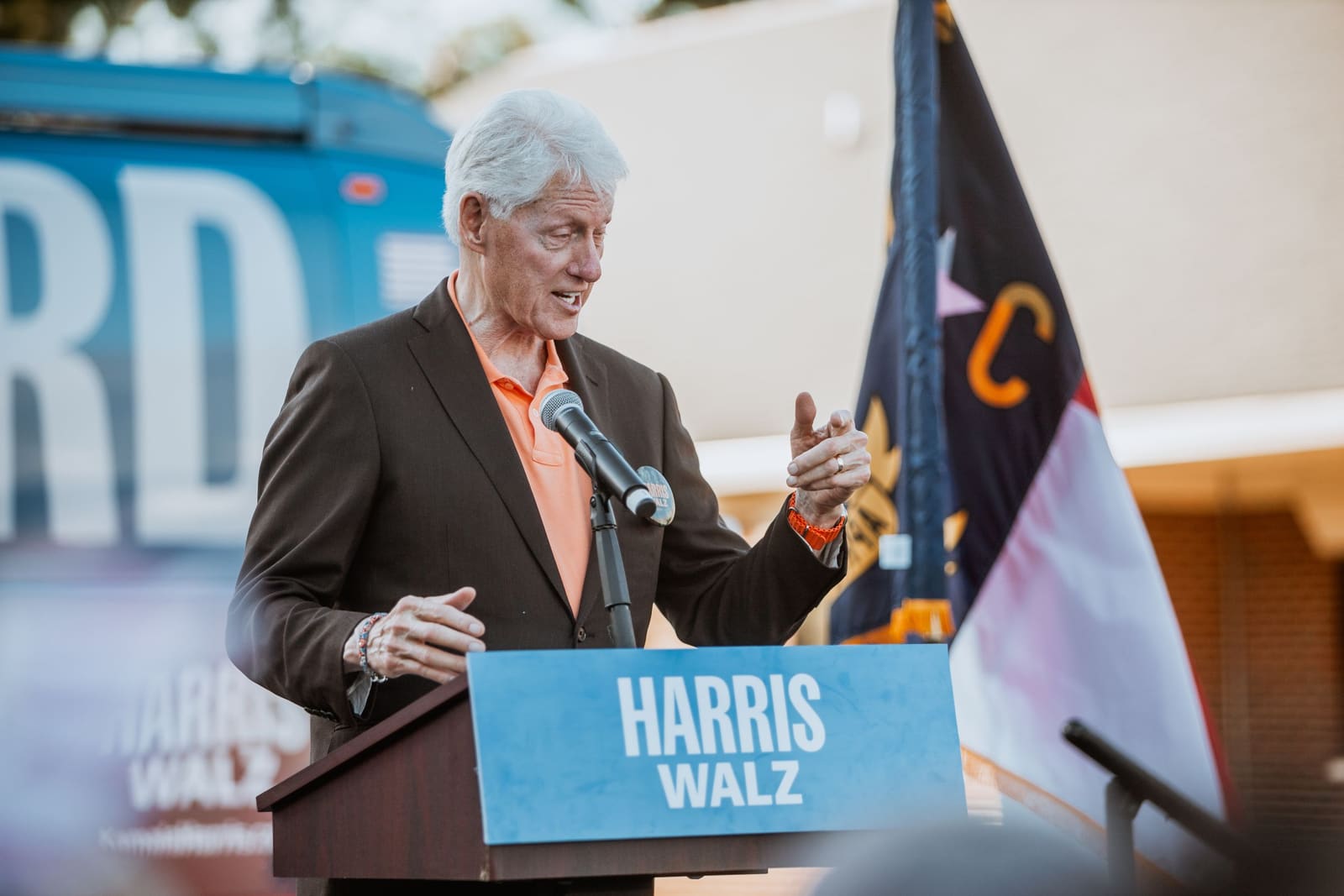 Bill Clinton speaks at an outdoor podium in Greenville, NC