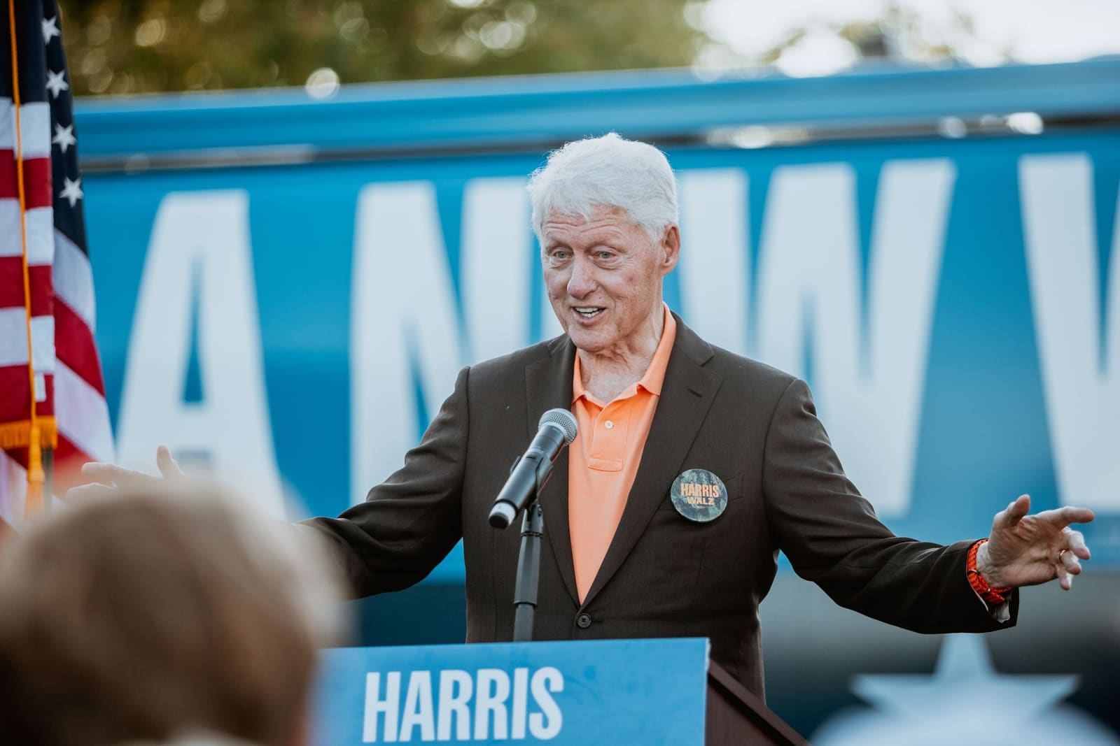 Bill Clinton gestures at the podium beside an American flag