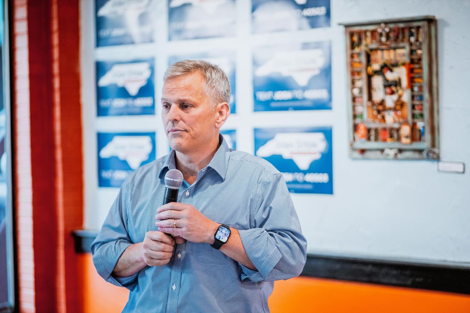 Josh Stein speaks with a microphone at a campaign stop in Greenville, NC