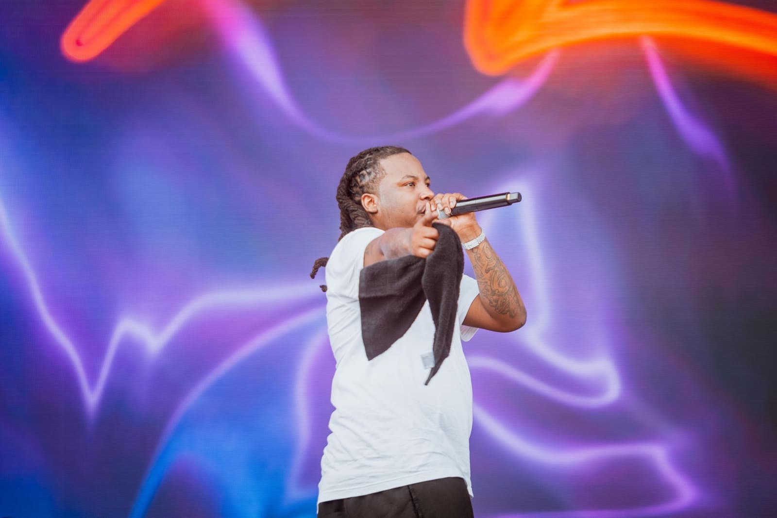 A rapper performs against purple and blue lights at Dreamville Festival, Raleigh, 2025