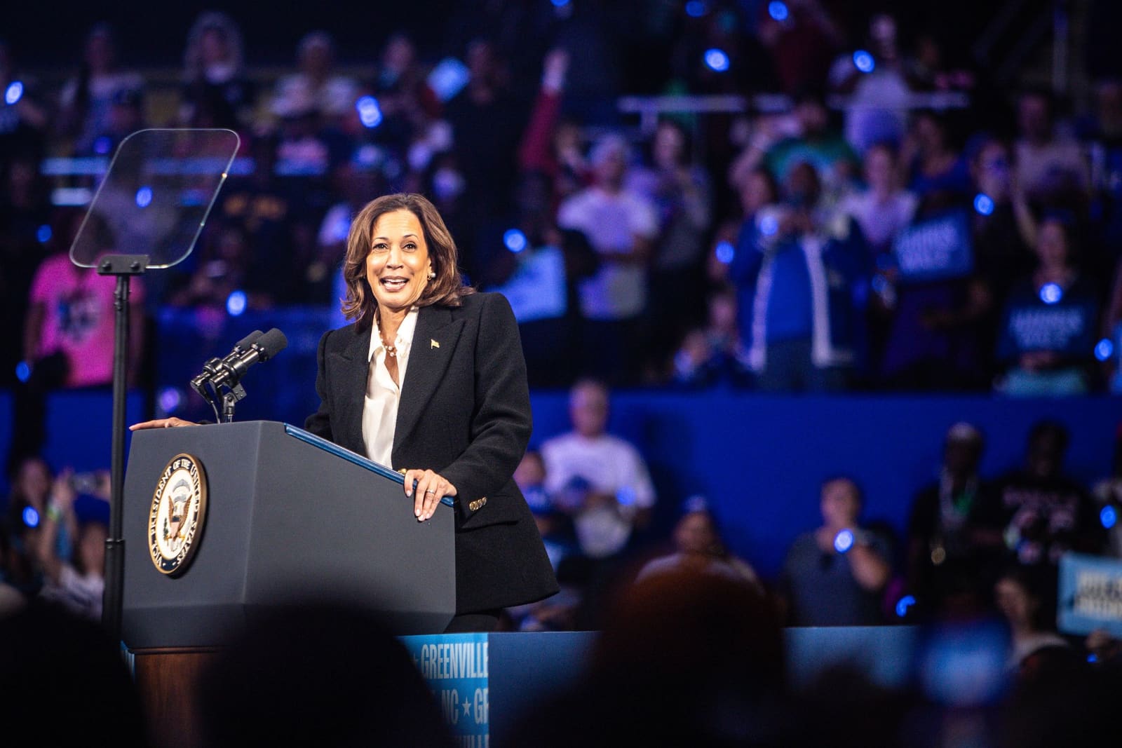 Kamala Harris smiles at the podium before a large crowd in Greenville, NC