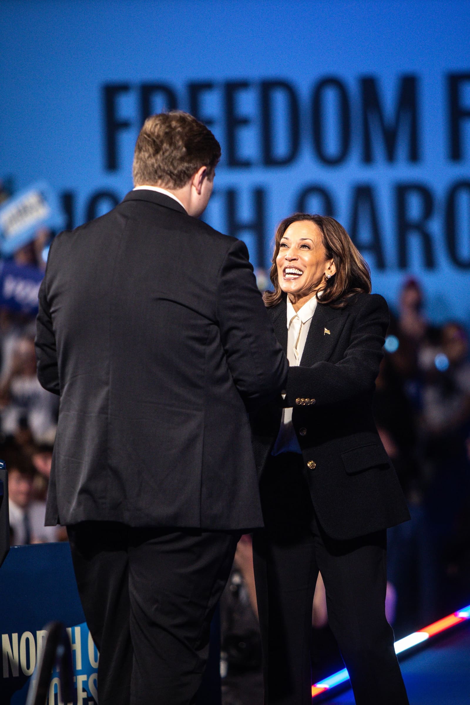 Kamala Harris greets a speaker on stage at Minges Coliseum, Greenville, NC
