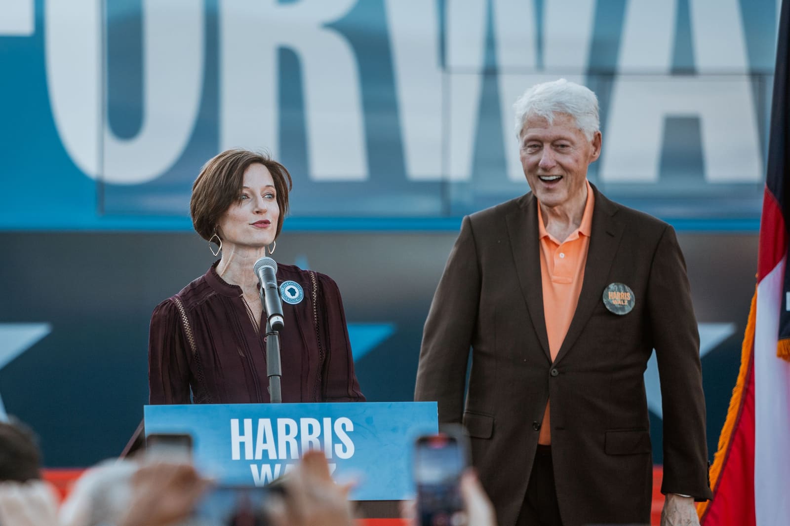 Bill Clinton and another speaker on stage before the crowd