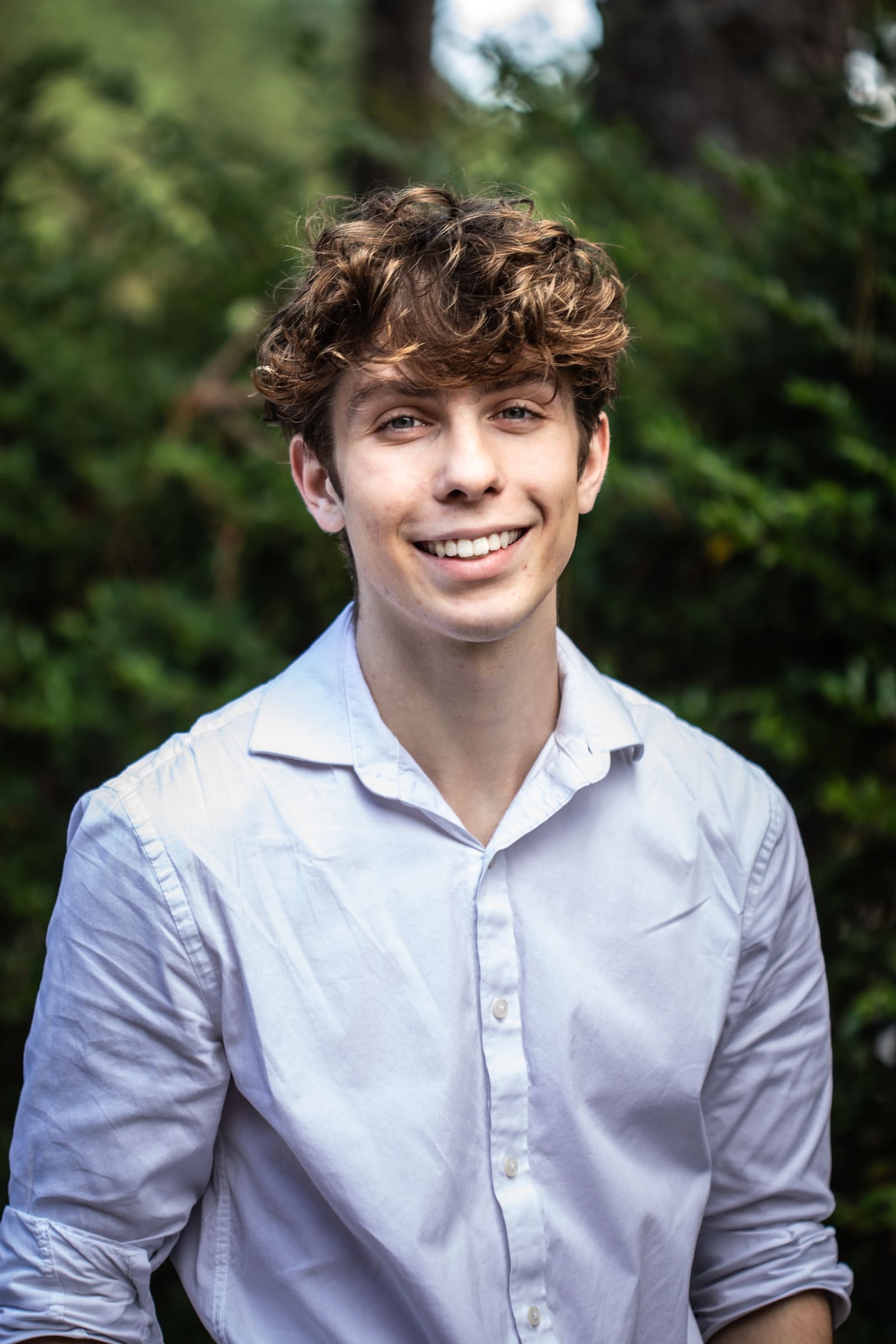 Gabe Key smiling in a white shirt outdoors