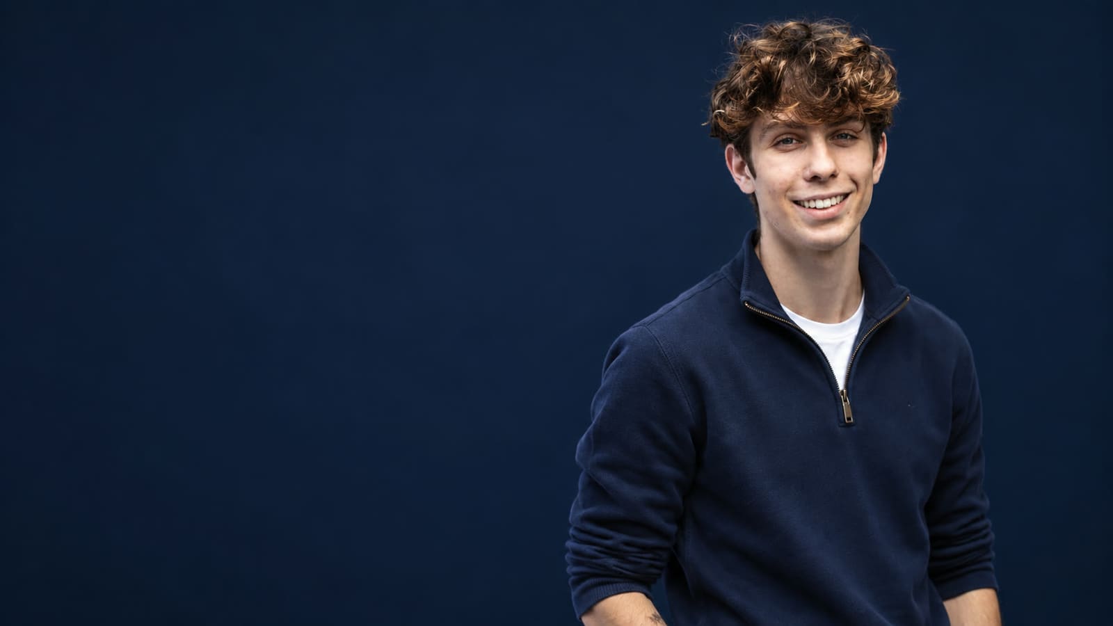 Gabe Key smiling in a navy quarter-zip against a navy backdrop