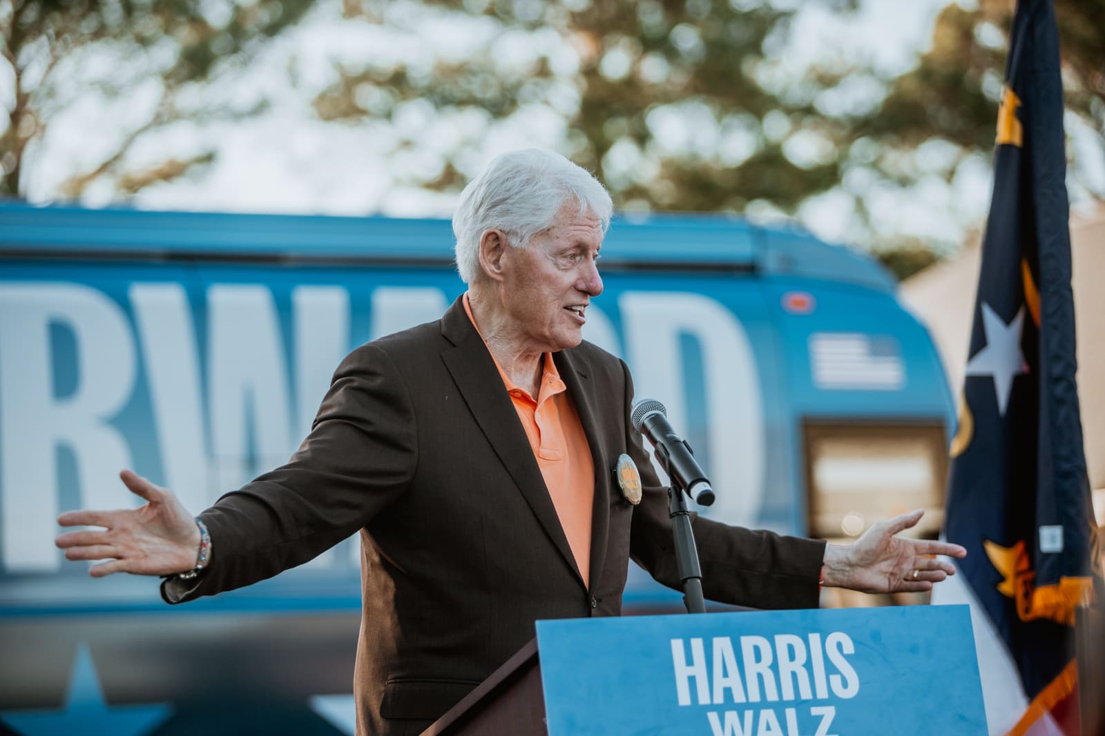 Bill Clinton with arms open at the lectern