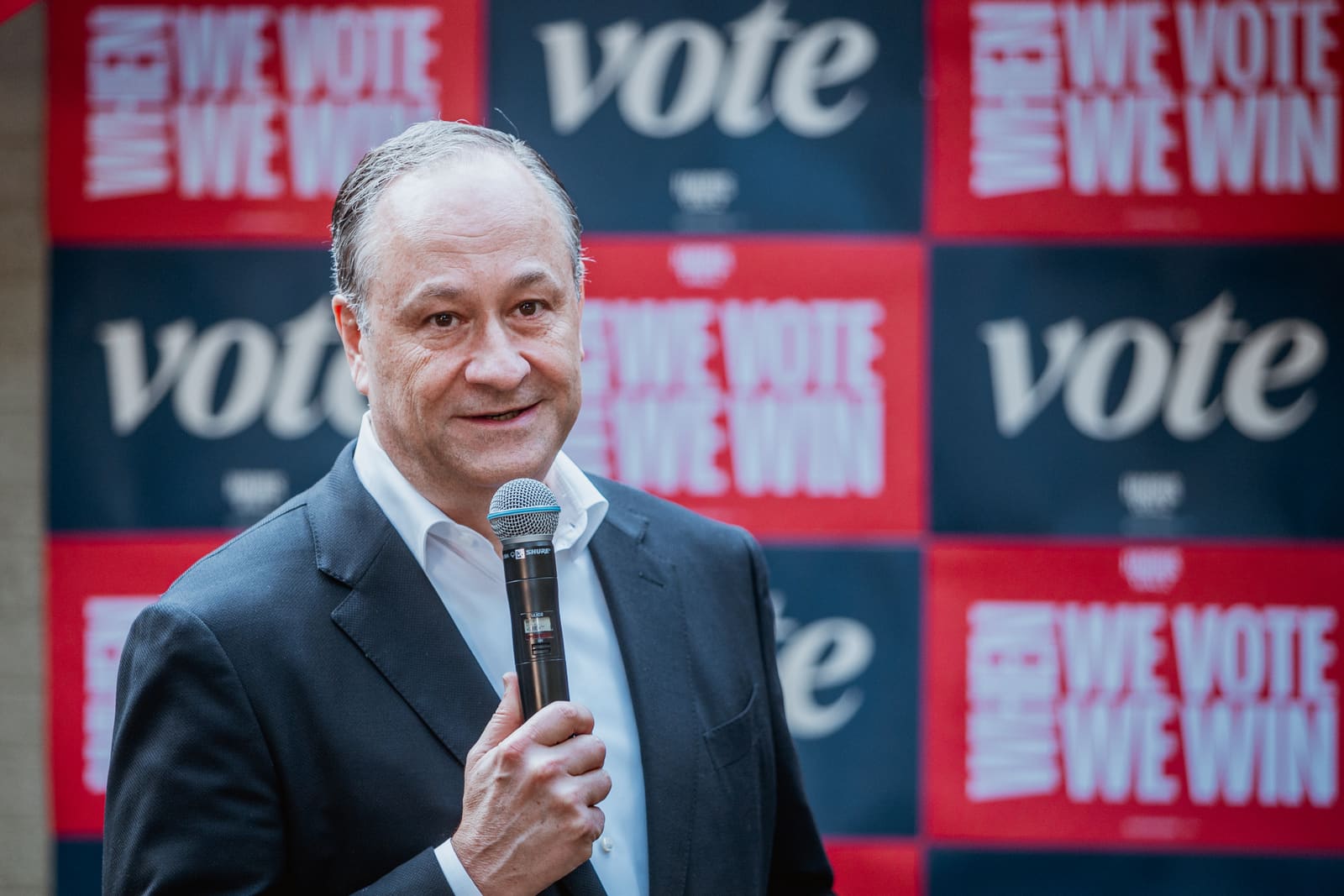 Doug Emhoff smiling with a microphone