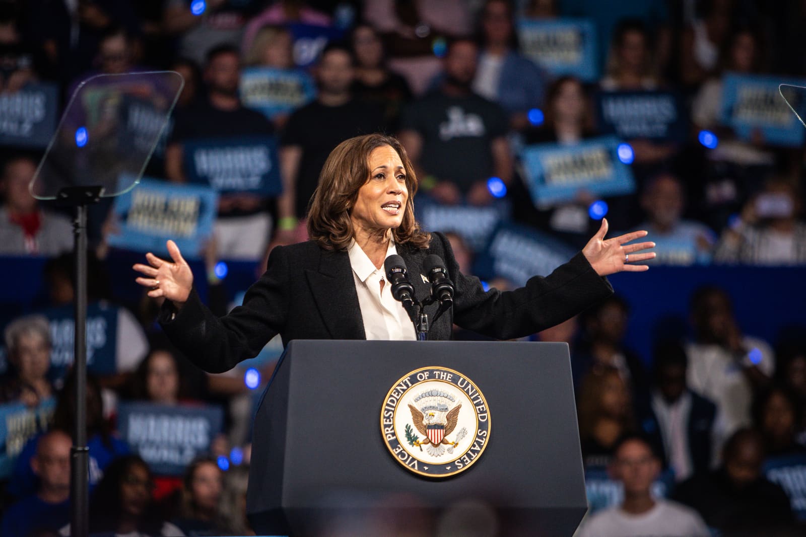 Kamala Harris with arms outstretched at the Vice President podium, Minges Coliseum