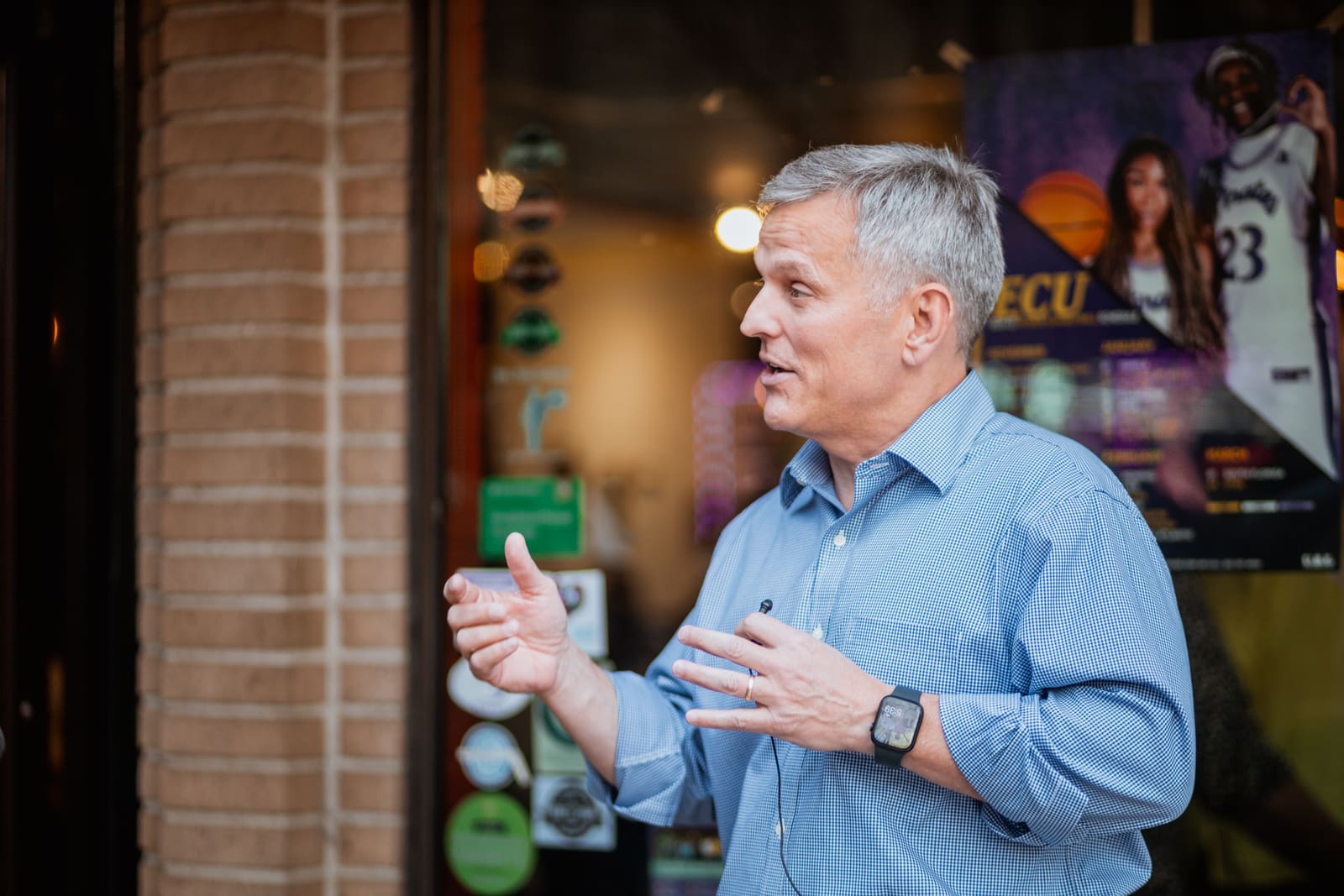 Josh Stein talking outside a storefront